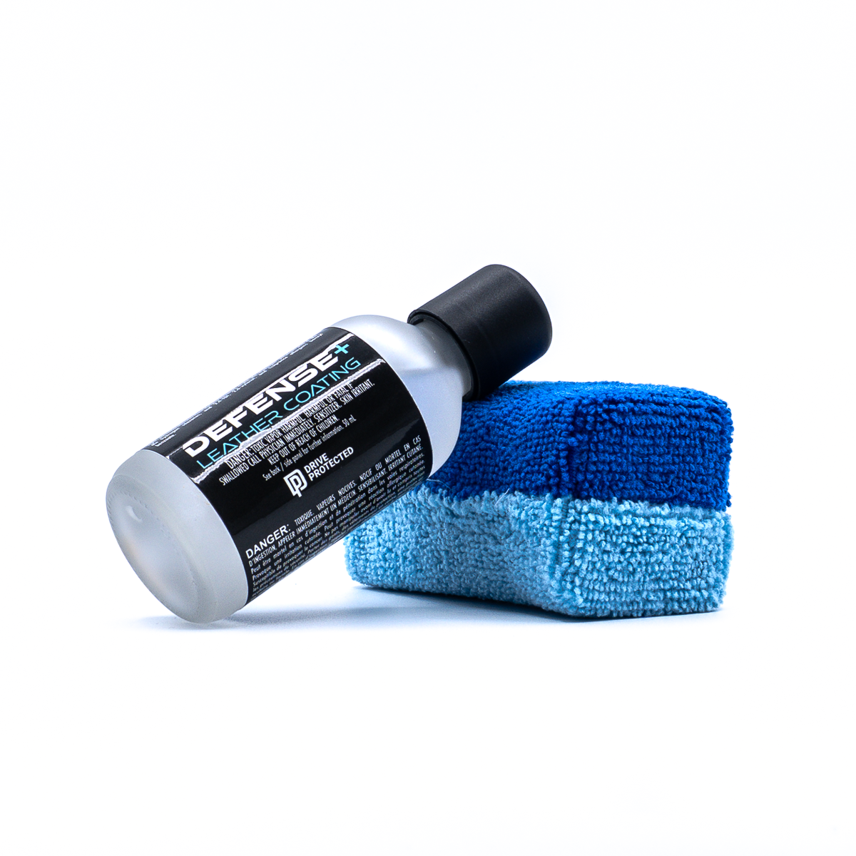Bottle of Defense+ Leather Coating by Drive Protected leaning against an applicator pad