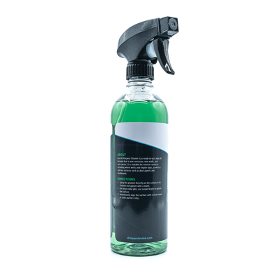 Clear spray bottle with black nozzle and green liquid on a white background