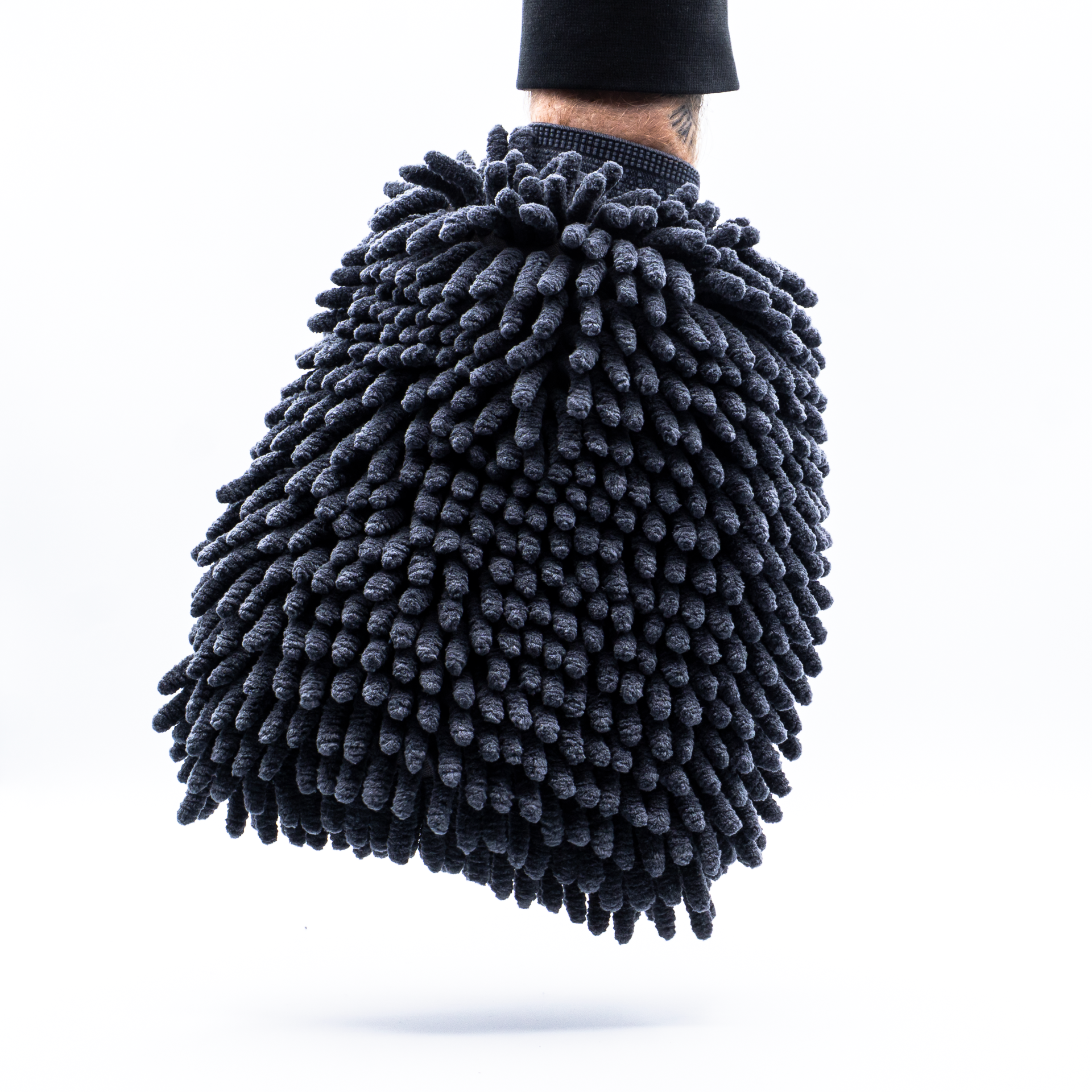 Black wash mitt held by a person on a white background