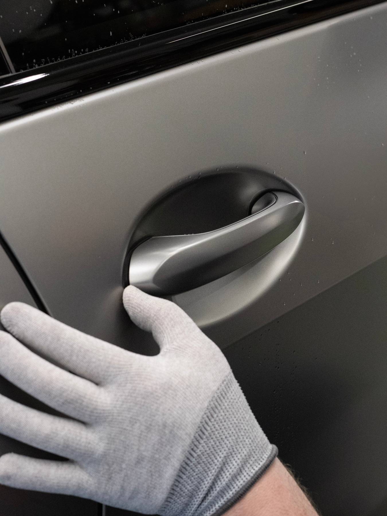 Close-up of a wrap glove working ppf around a door handle