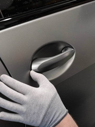 Close-up of a wrap glove working ppf around a door handle